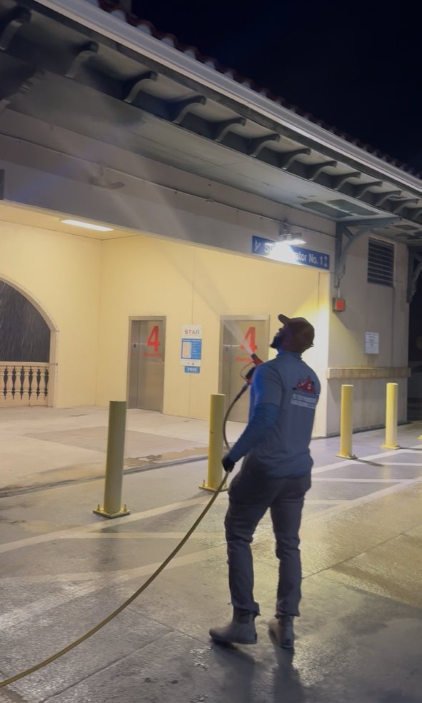 Pro Vets Pressure Washing crew member washing a commercial building exterior with professional pressure washing equipment
